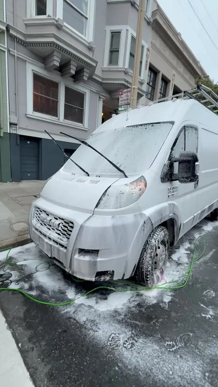 Golden Bay foam-washing a Ram Promaster camper van on a San Francisco street — real job